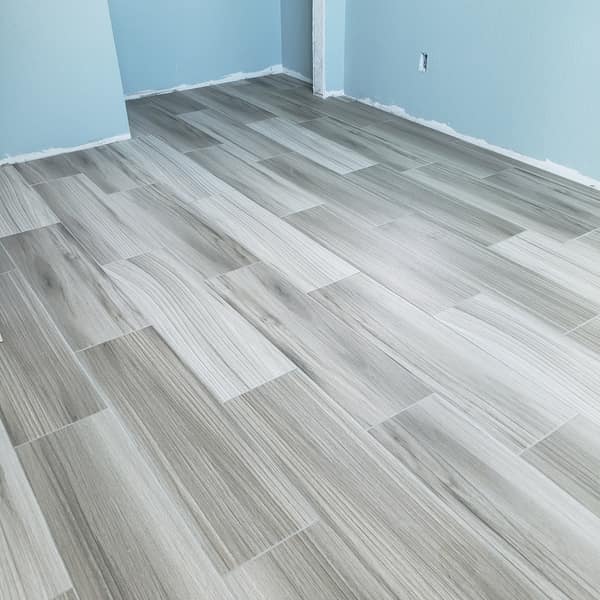 Gray wood-look porcelain plank tile floor in an empty room