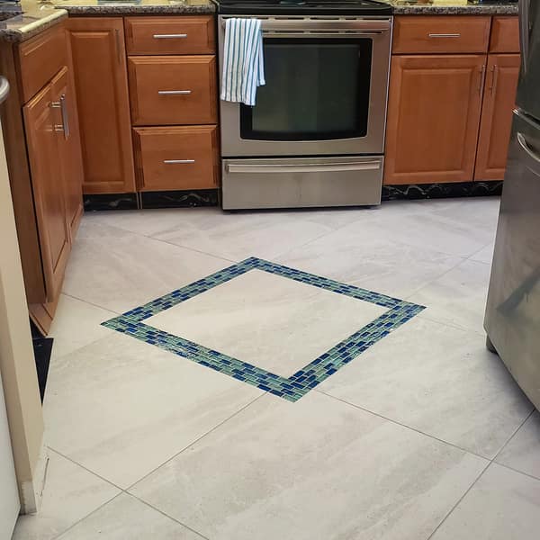 Kitchen tile floor with a blue glass mosaic accent border