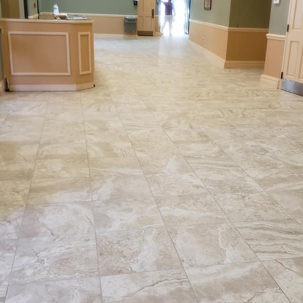Large-format beige tile floor along a long hallway