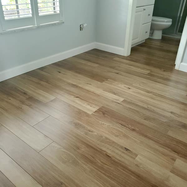 Light oak luxury vinyl plank floor in a room next to a bathroom