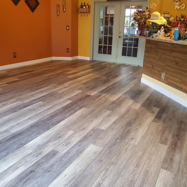 Luxury vinyl plank flooring in a living room with French doors