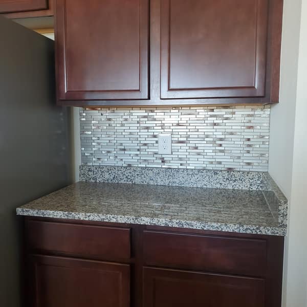 Glass and stone mosaic backsplash above a granite counter