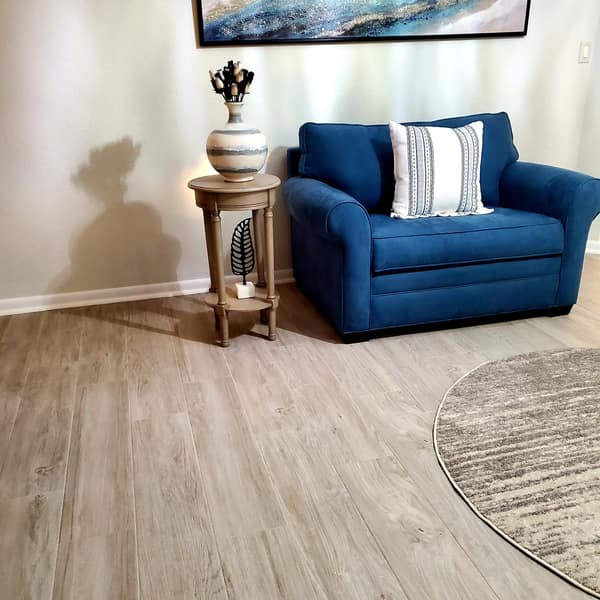 Wood-look plank floor in a living room with a blue armchair