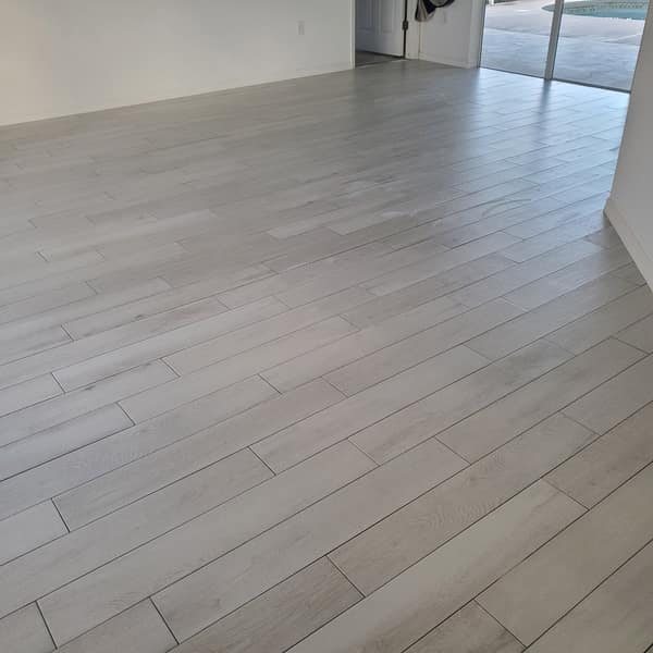 Light gray wood-look plank tile floor in an open room