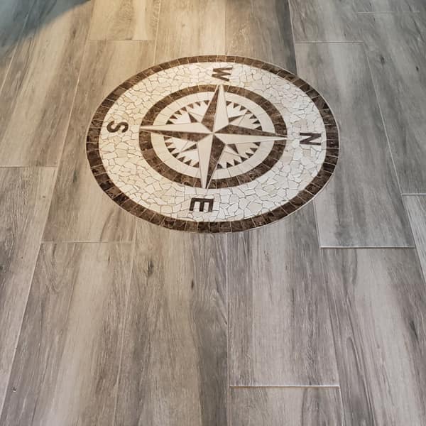 Wood-look plank tile floor with an inlaid compass rose medallion